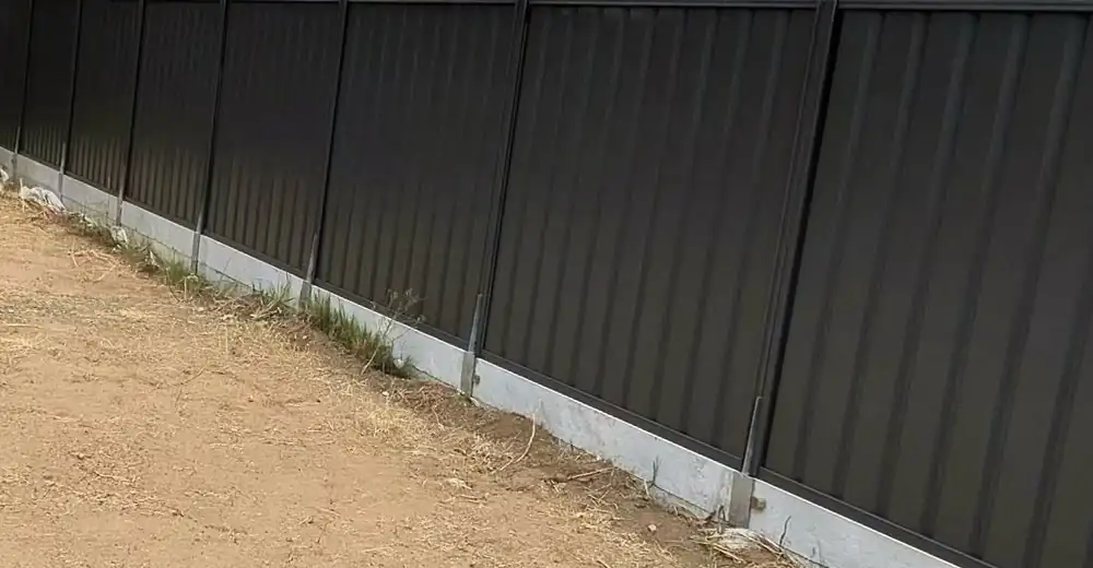 Colorbond fence built by JC Fencing on a concrete retaining wall